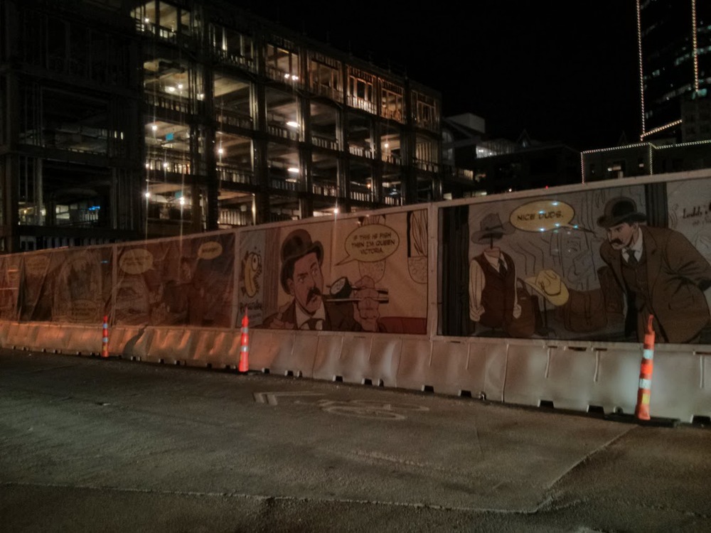 It's a comic strip spanning hundreds of feet along a construction fence. An ad for... something.